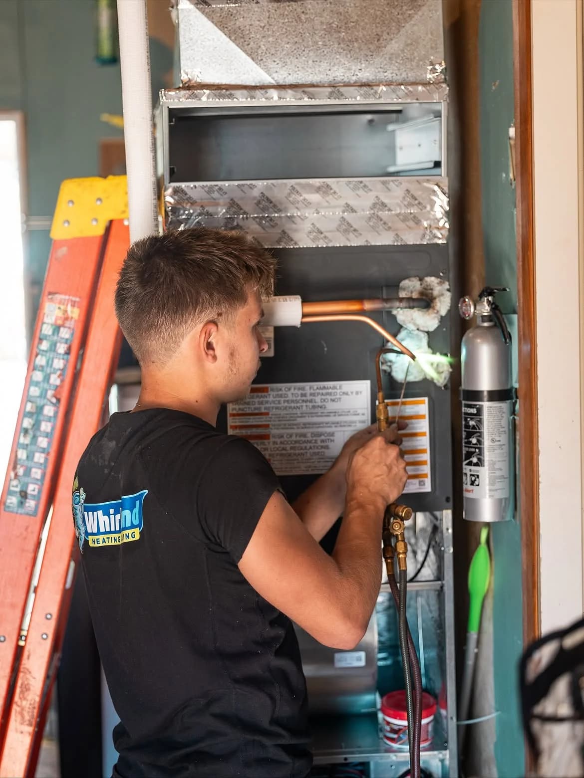Whirlwind technician working inside an open furnace cabinet