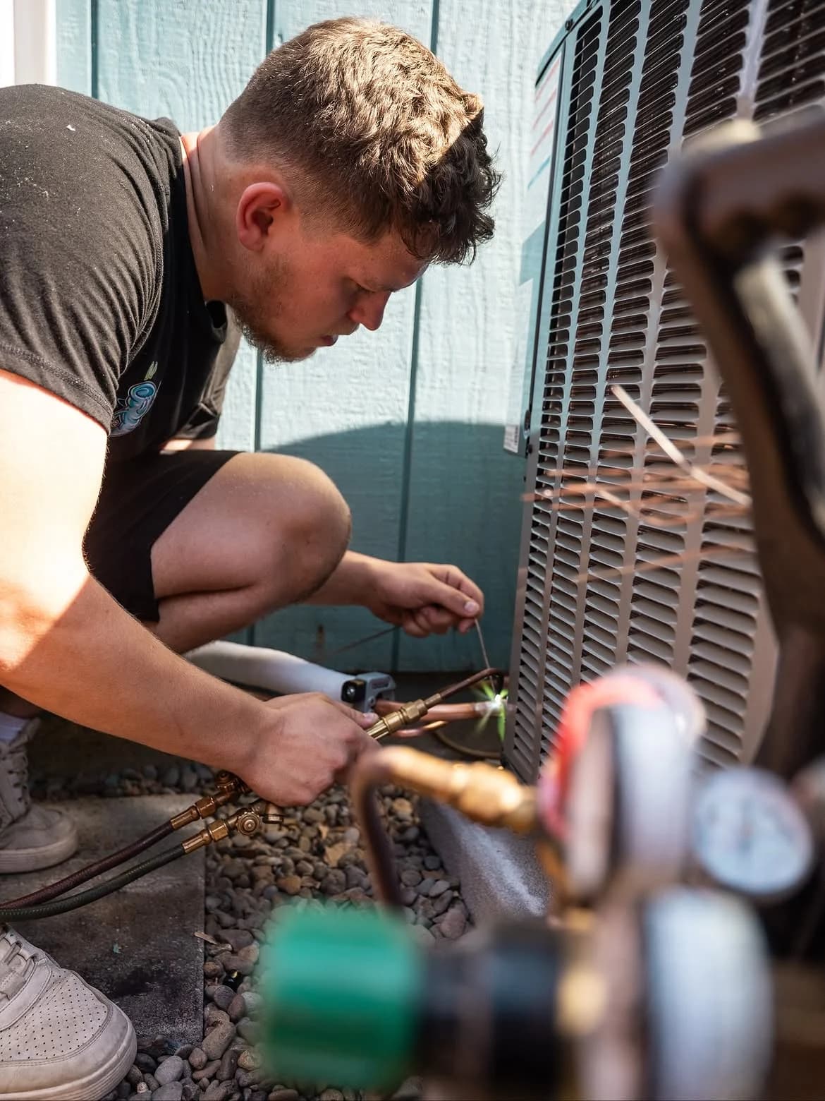 Whirlwind technician using service tools at an outdoor AC unit
