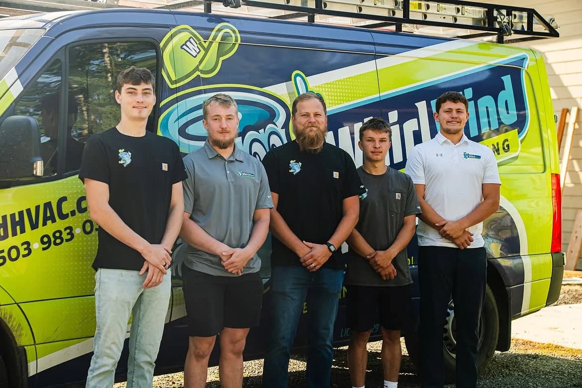 Five Whirlwind Heating & Cooling crew members standing in front of their branded service van